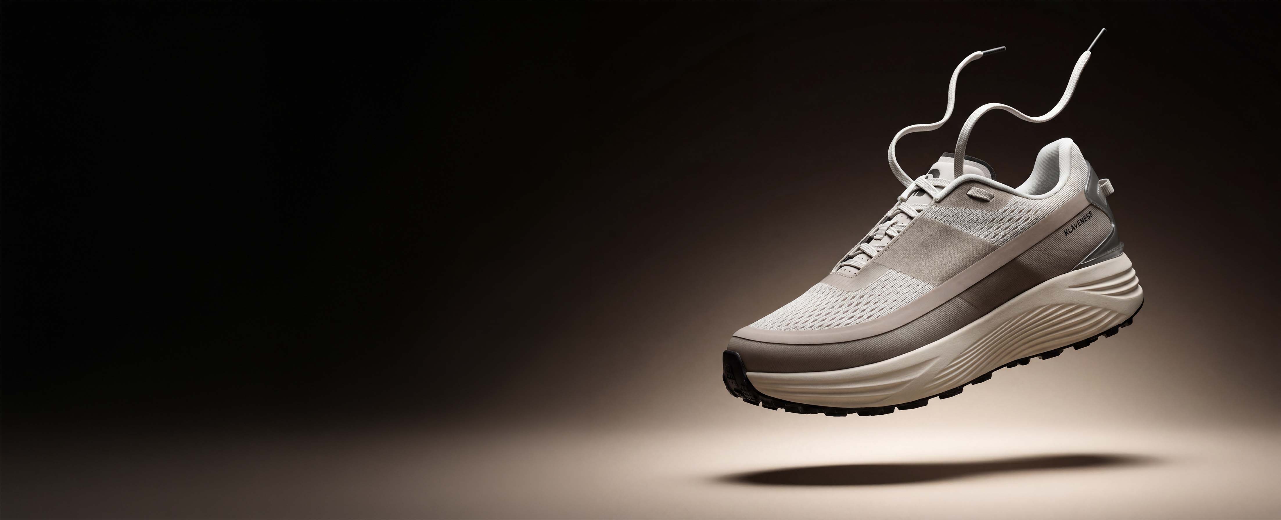 The PSGEN3 Carbitex sneaker in beige, seen from the side under hard studio light.