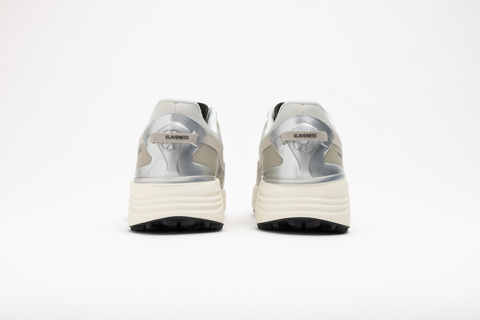 A pair of beige PSGEN3 sneakers from behind, with silver heel counters.