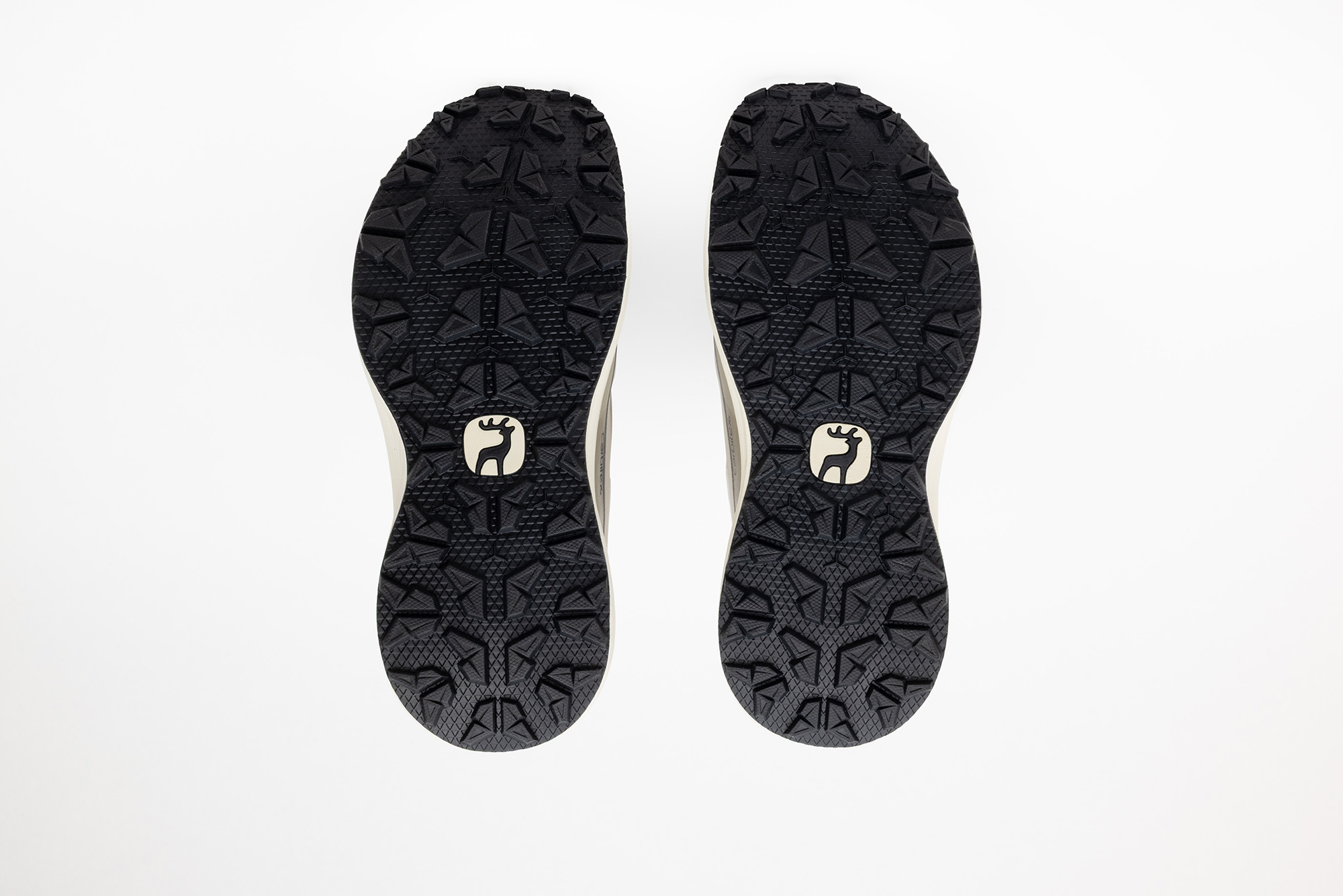 The black outsoles of the beige PSGEN3 sneakers.